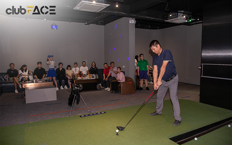 A man playing golf in a private simulator room