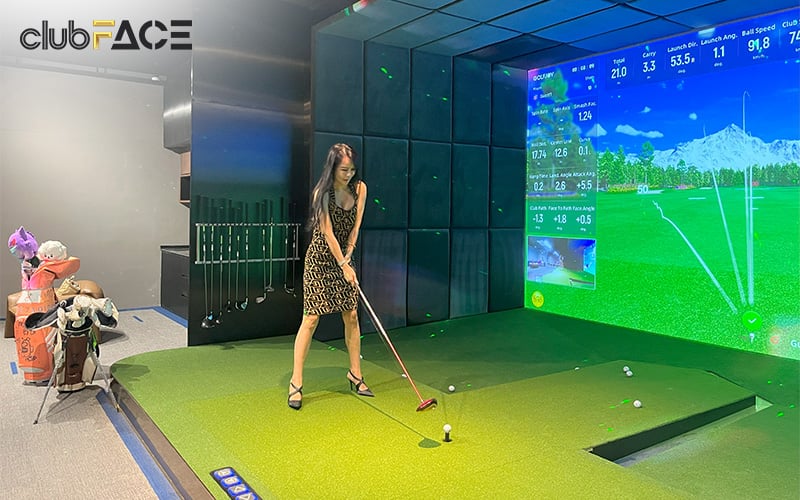 A woman playing on an indoor golf simulator