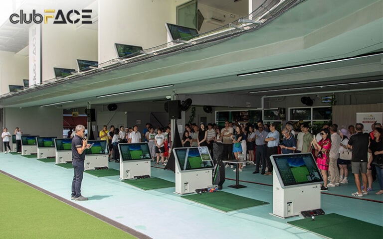 Crowd at a golf driving range with digital screens