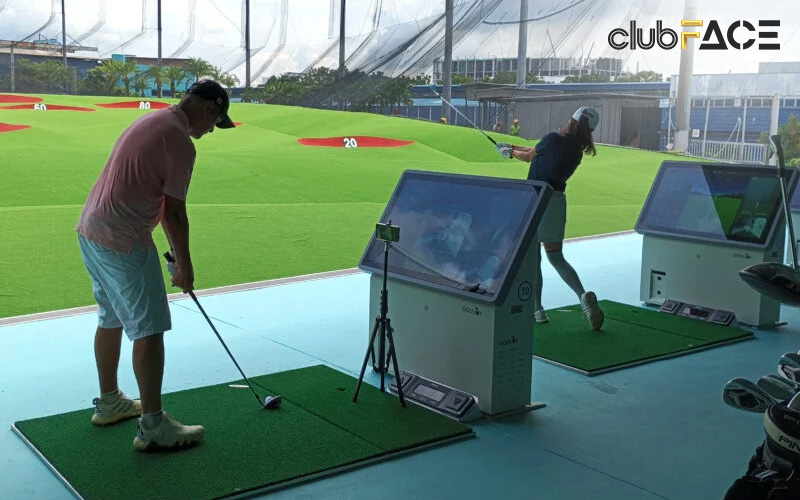 Golfers using swing analysis simulator to improve their form
