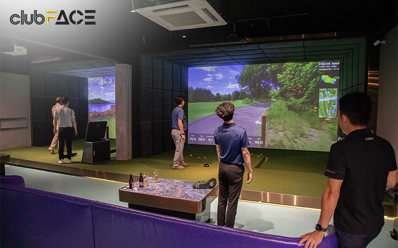 Group of people playing virtual golf indoors at clubFACE.