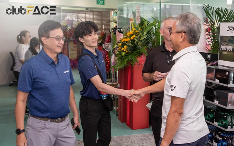 Two men shaking hands at grand opening event