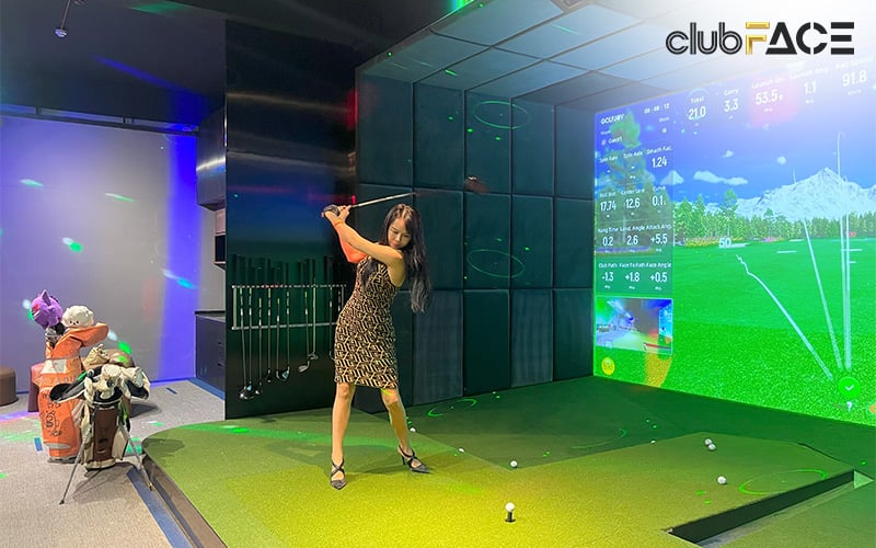 Woman practicing her swing on a golf simulator.