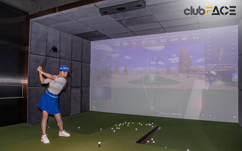 woman playing golf simulation in a private room